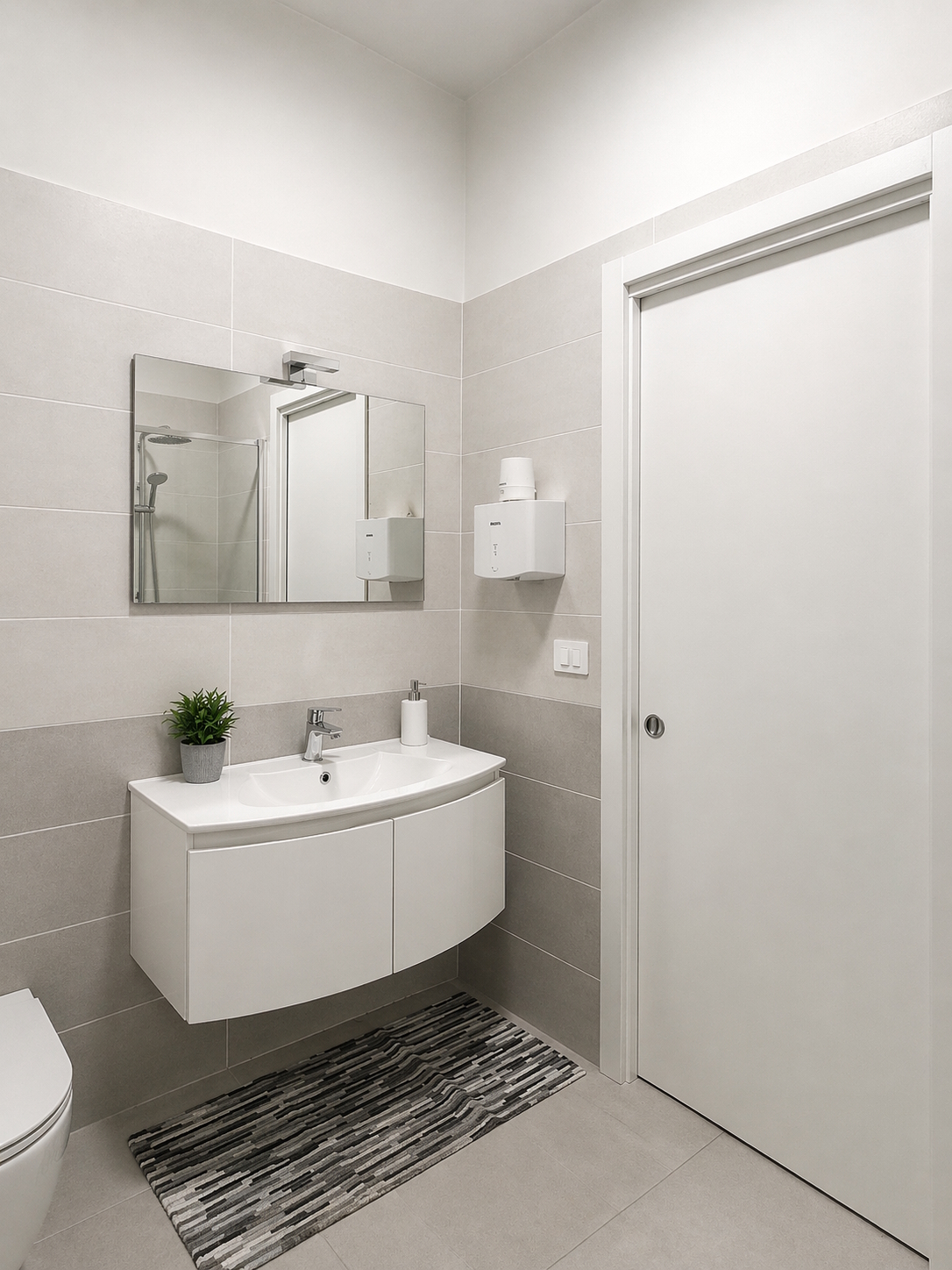 Bagno moderno con mobile sospeso, specchio retroilluminato e doccia